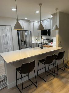 Finished kitchen remodel with pendant lights, recessed lighting, and island outlets